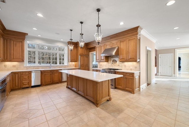 kitchen with a center island, stainless steel appliances, light countertops, hanging light fixtures, and under cabinet range hood