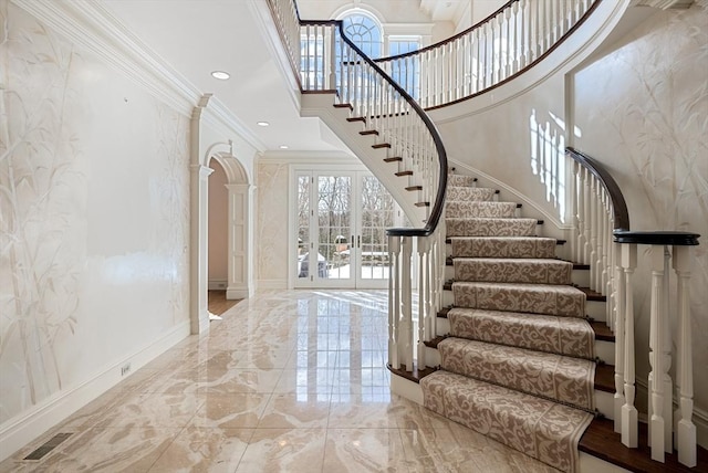 stairs with arched walkways, visible vents, baseboards, marble finish floor, and crown molding