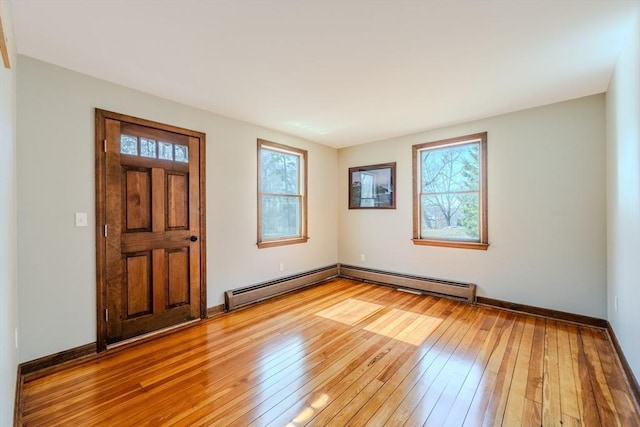 entrance foyer featuring a wealth of natural light, light wood-style flooring, and a baseboard heating unit