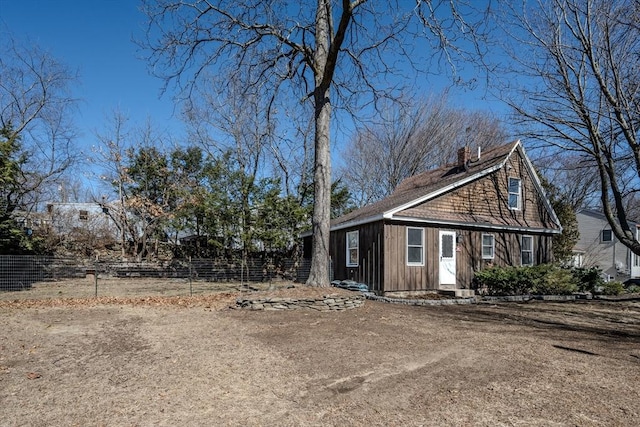 view of front of property with a chimney and fence