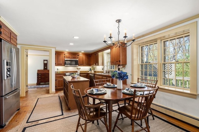 dining area with an inviting chandelier, baseboards, baseboard heating, recessed lighting, and light wood-type flooring
