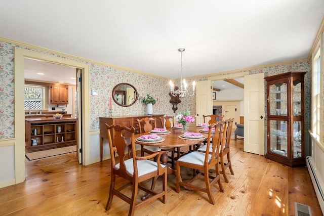 dining space with visible vents, wallpapered walls, a wainscoted wall, a baseboard heating unit, and light wood finished floors