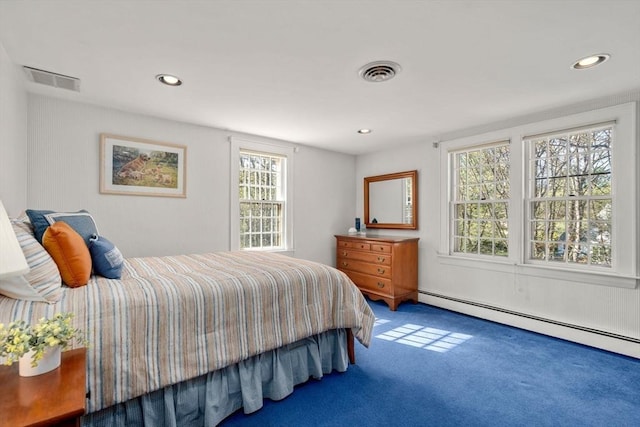 carpeted bedroom with multiple windows, a baseboard heating unit, and visible vents