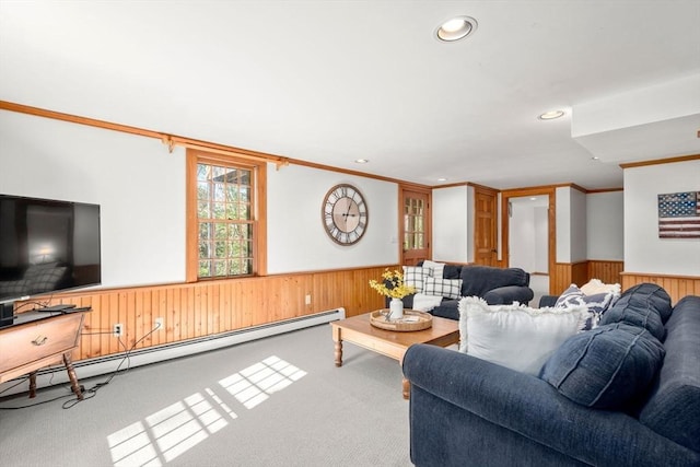 living area with wooden walls, a wainscoted wall, a baseboard radiator, and carpet flooring