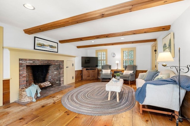 living area with recessed lighting, a brick fireplace, beam ceiling, and hardwood / wood-style flooring