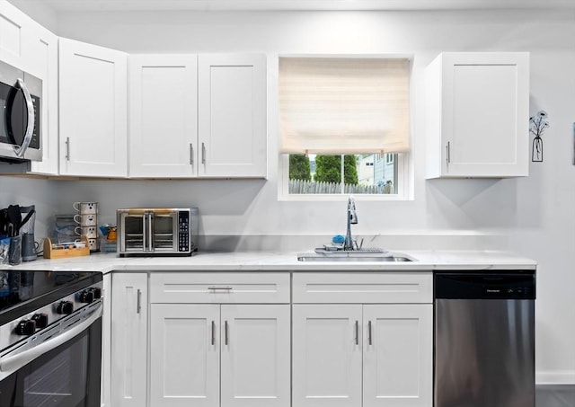 50 Frankfort St Unit 1, Fitchburg, MA 01420 - kitchen with appliances with stainless steel finishes, a sink, white cabinetry, and light countertops