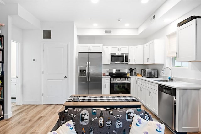50 Frankfort St Unit 1, Fitchburg, MA 01420 - kitchen with appliances with stainless steel finishes, a sink, light wood-type flooring, light countertops, and white cabinets