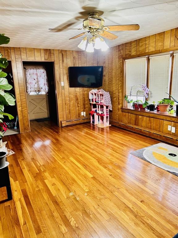 interior space featuring a baseboard heating unit, a baseboard radiator, light wood-style flooring, and a ceiling fan