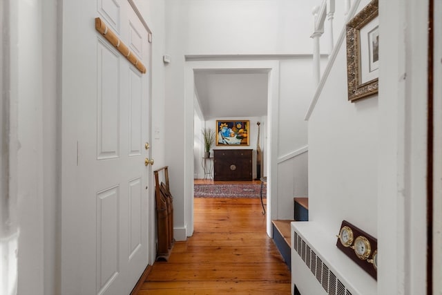 hallway with radiator heating unit and light wood-type flooring