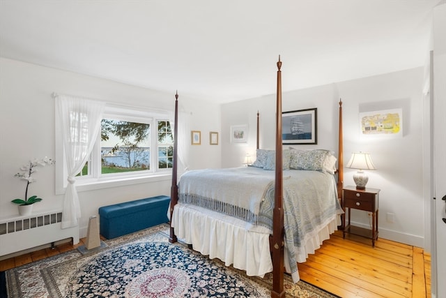 bedroom featuring radiator heating unit and wood-type flooring