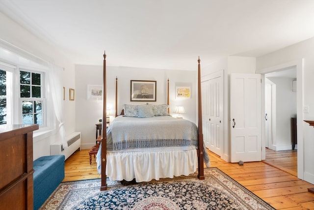 bedroom with light hardwood / wood-style flooring, a closet, and radiator