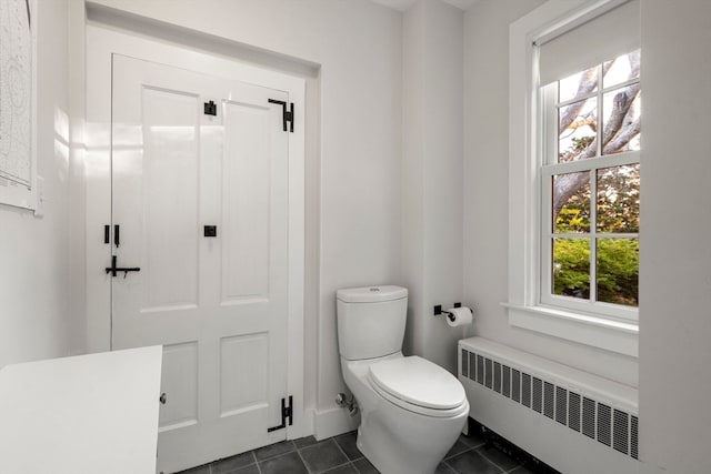 bathroom featuring radiator, toilet, and tile patterned flooring