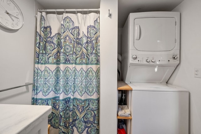 clothes washing area featuring stacked washer / dryer