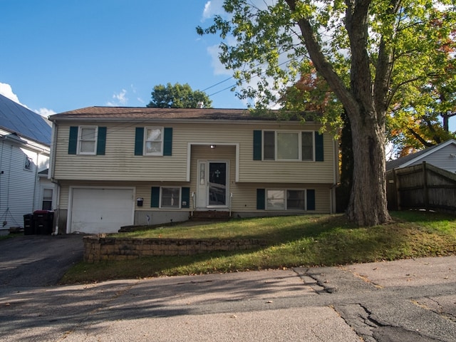 raised ranch with a front yard and a garage