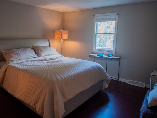 bedroom with dark hardwood / wood-style floors