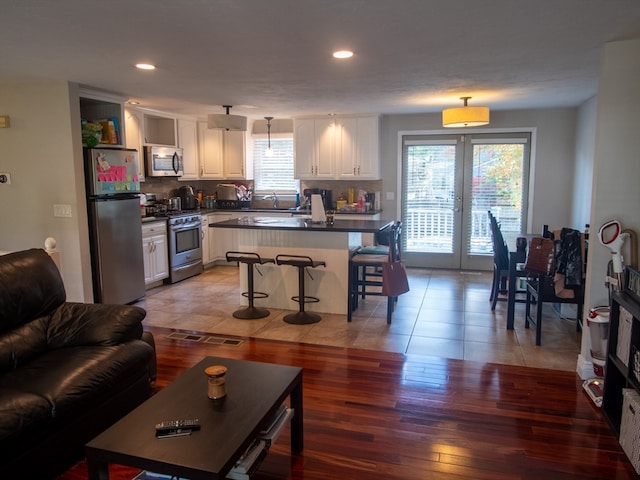 living room featuring hardwood / wood-style flooring, sink, and plenty of natural light