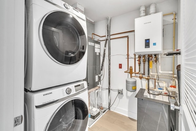 washroom featuring light hardwood / wood-style floors, tankless water heater, and stacked washer and clothes dryer