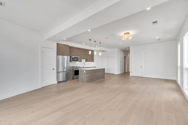 unfurnished living room with sink and light hardwood / wood-style floors