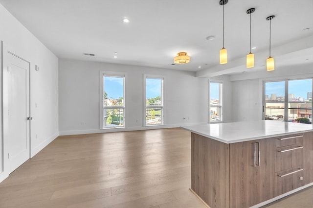 kitchen featuring a center island, pendant lighting, and light wood-type flooring