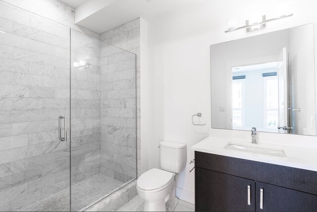 bathroom featuring vanity, a shower with shower door, toilet, and tile patterned floors