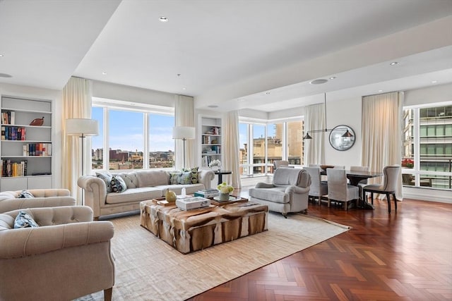 living room with dark parquet flooring and built in features