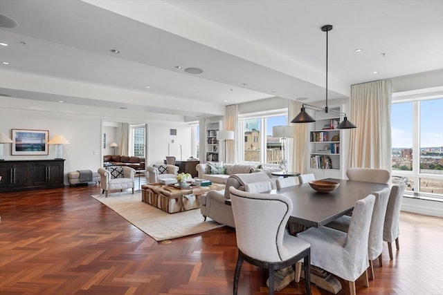 dining area with dark parquet flooring and a healthy amount of sunlight