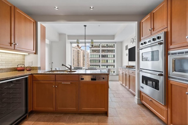 kitchen featuring sink, beverage cooler, a notable chandelier, kitchen peninsula, and appliances with stainless steel finishes