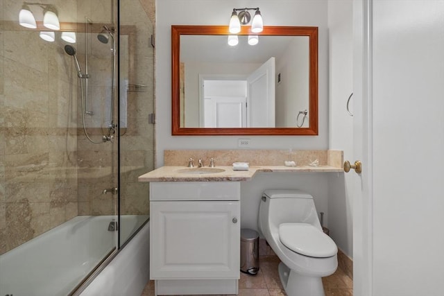 full bathroom featuring combined bath / shower with glass door, tile patterned floors, vanity, and toilet