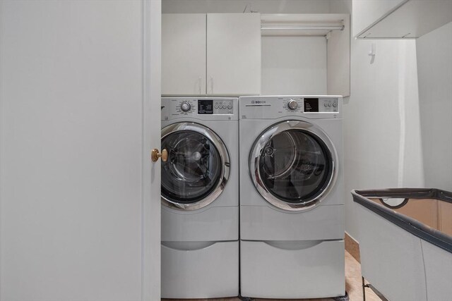 washroom featuring cabinets and washing machine and dryer