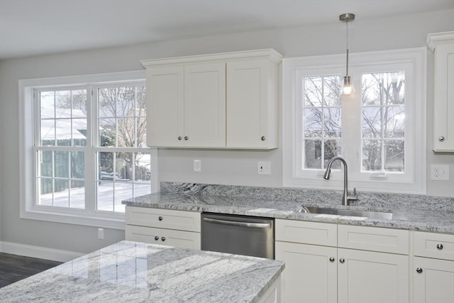 kitchen featuring sink, dishwasher, hanging light fixtures, a wealth of natural light, and white cabinets