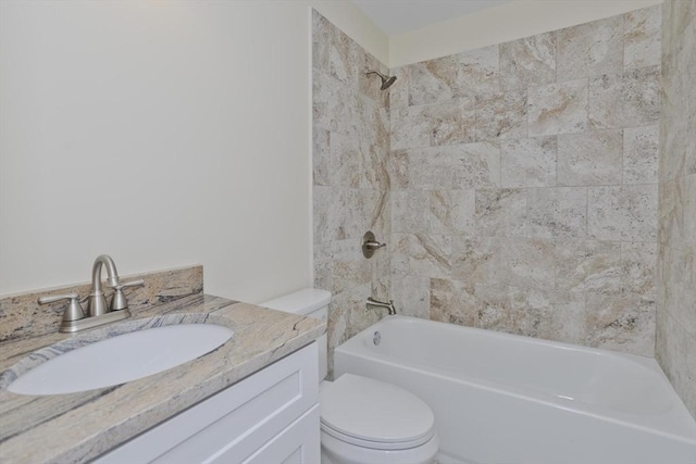 full bathroom featuring vanity, tiled shower / bath combo, and toilet