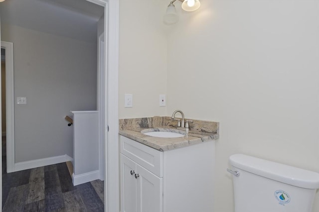 bathroom with vanity, toilet, and wood-type flooring