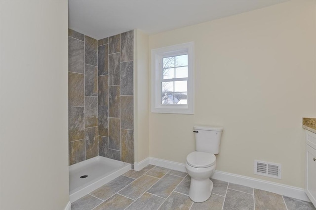 bathroom featuring vanity, toilet, and a shower