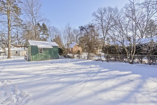 yard covered in snow featuring a storage shed