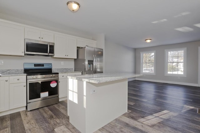 kitchen featuring white cabinetry, dark hardwood / wood-style flooring, a center island, and appliances with stainless steel finishes