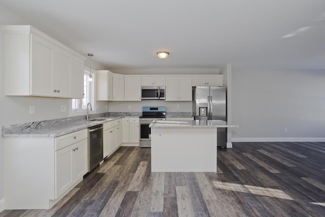 kitchen with pendant lighting, white cabinetry, stainless steel appliances, and sink