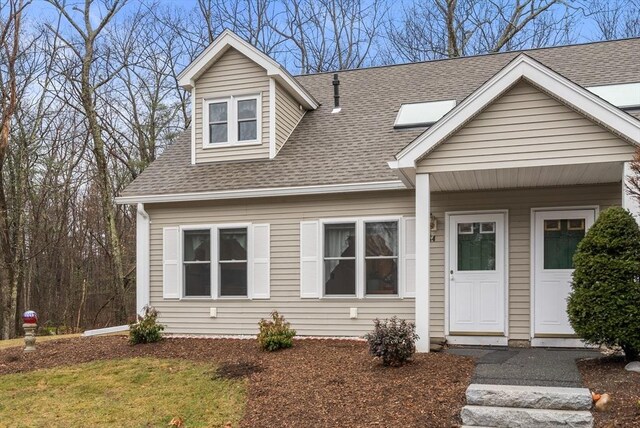 cape cod-style house featuring roof with shingles