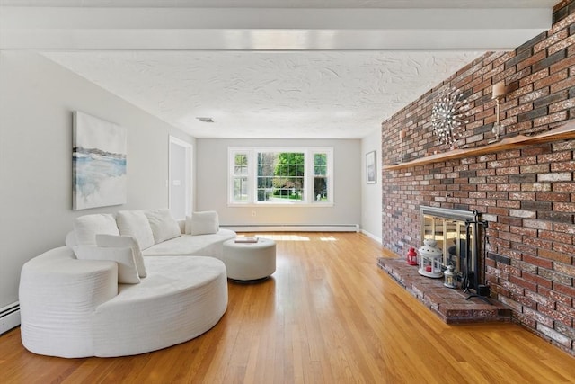 living area with a baseboard heating unit, wood finished floors, and brick wall
