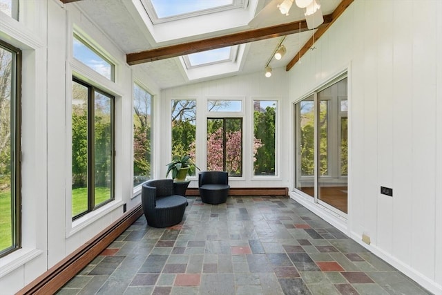 sunroom with a skylight, vaulted ceiling, a baseboard radiator, healthy amount of natural light, and stone finish flooring