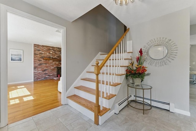 stairs featuring tile patterned flooring, baseboards, a baseboard radiator, and a chandelier