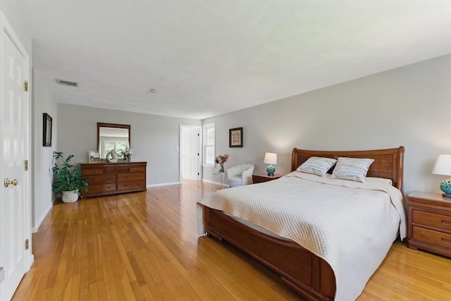 bedroom featuring light wood finished floors and baseboards