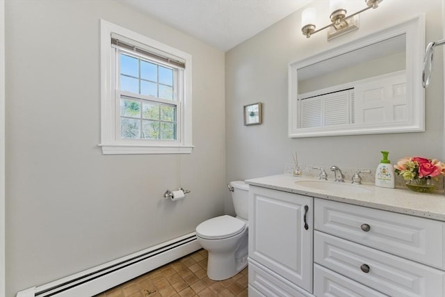 bathroom featuring baseboard heating, toilet, and vanity