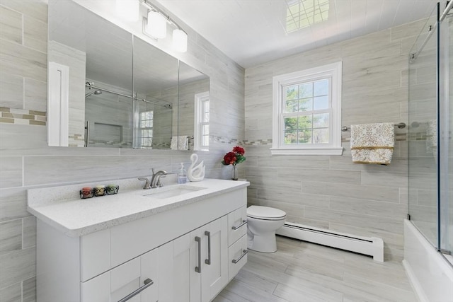 bathroom with a baseboard radiator, tile walls, toilet, and vanity