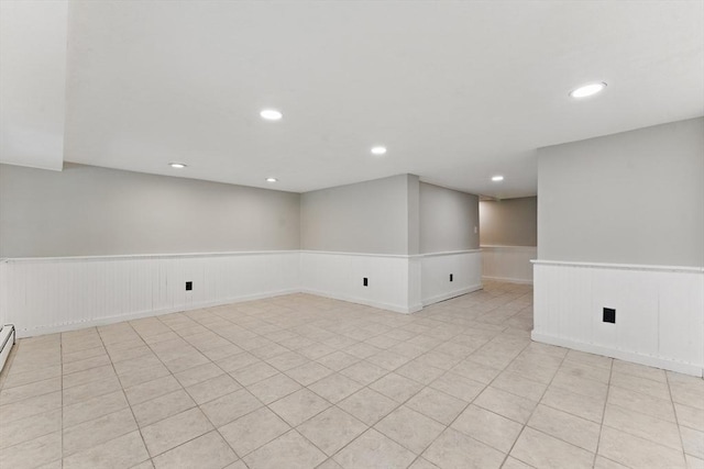 spare room featuring a wainscoted wall, recessed lighting, and light tile patterned floors
