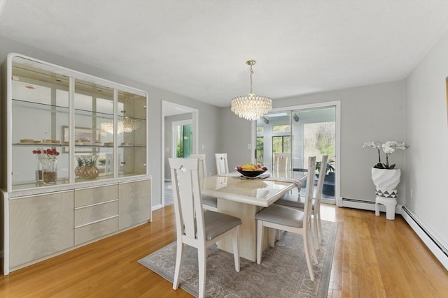dining room with baseboard heating, a chandelier, and light wood-type flooring