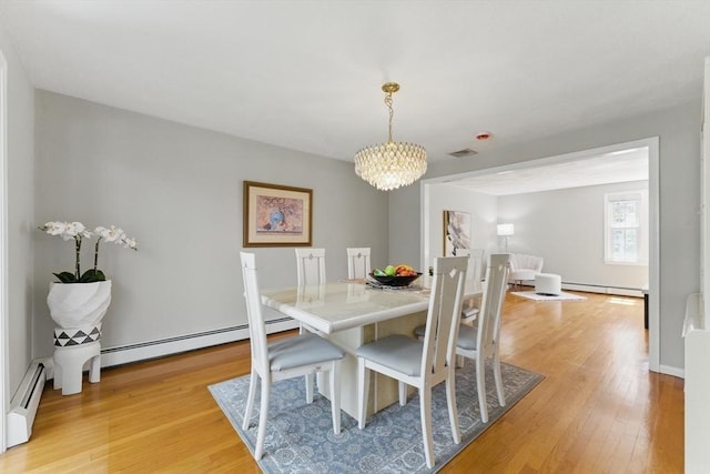 dining space featuring a chandelier, light wood-type flooring, a baseboard heating unit, and a baseboard radiator
