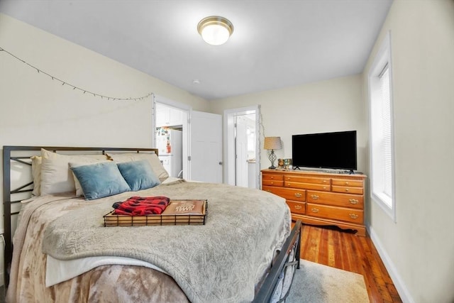 bedroom featuring wood finished floors and baseboards