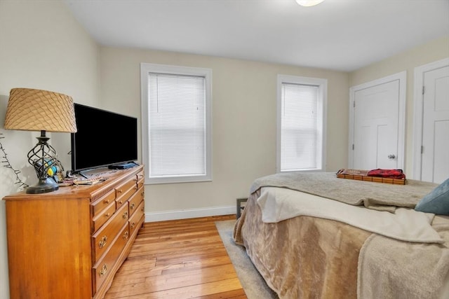 bedroom with light wood-style flooring and baseboards