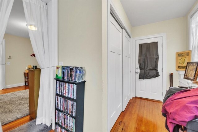 hallway featuring light wood-type flooring and baseboards