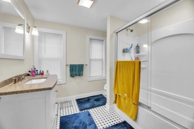 full bathroom with enclosed tub / shower combo, vanity, toilet, and baseboards